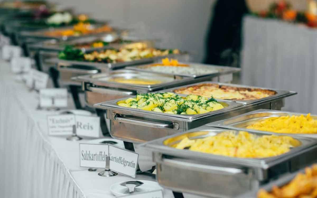 Long buffet line of chafing dishes with rice, potatoes, and party mains — birthday and party catering in Kolkata by Parsha Caterer
